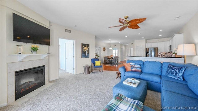 living area featuring light carpet, visible vents, a ceiling fan, a fireplace, and recessed lighting