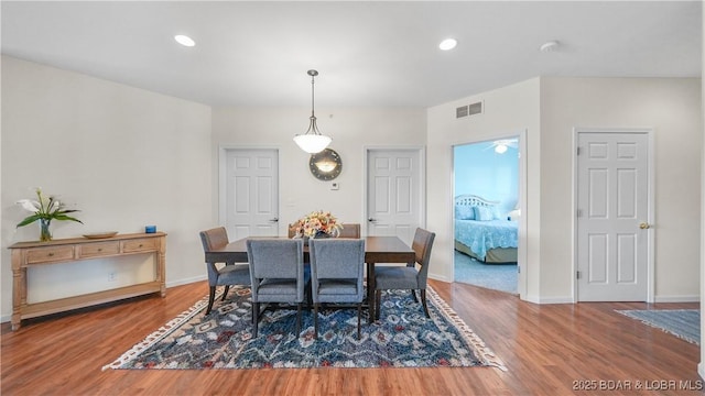 dining area with baseboards, wood finished floors, visible vents, and recessed lighting