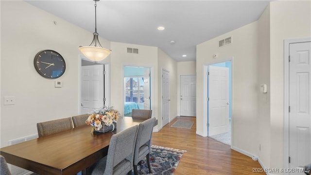 dining area with light wood-style floors, visible vents, and baseboards