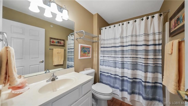 bathroom with a shower with shower curtain, vanity, and toilet