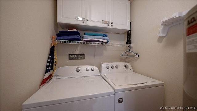 laundry room with washer and clothes dryer and cabinet space