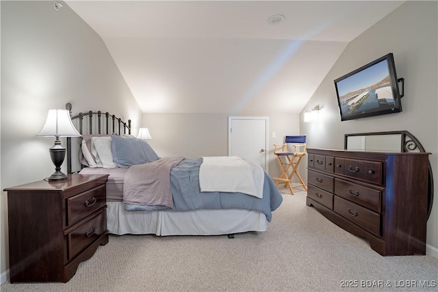 bedroom featuring lofted ceiling and light carpet