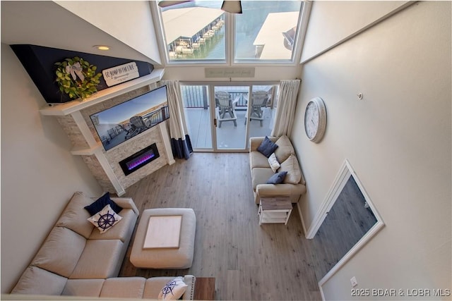 living room with a glass covered fireplace, wood finished floors, and baseboards