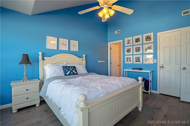 bedroom with visible vents, ceiling fan, vaulted ceiling, wood finished floors, and baseboards