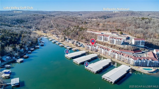 drone / aerial view featuring a water view and a forest view