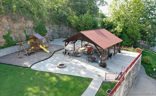 view of community with an outdoor fire pit, a patio, a gazebo, fence, and a yard