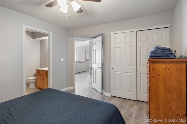 bedroom with baseboards, a ceiling fan, a textured ceiling, light wood-style floors, and a closet