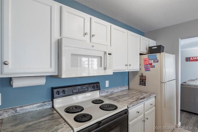 kitchen with white appliances, white cabinetry, light countertops, and a textured ceiling