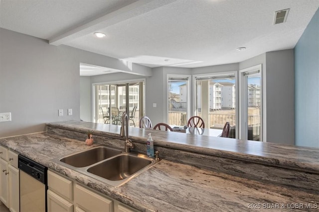 kitchen with visible vents, white cabinetry, a sink, a textured ceiling, and dishwasher