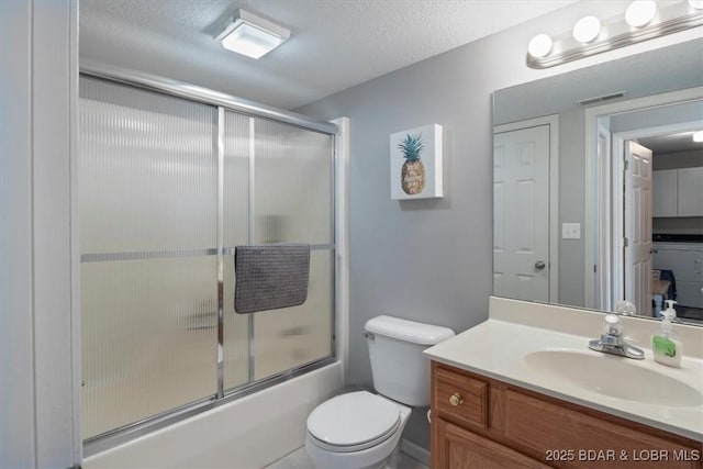 bathroom with a textured ceiling, toilet, bath / shower combo with glass door, visible vents, and vanity