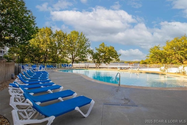 community pool featuring fence and a patio