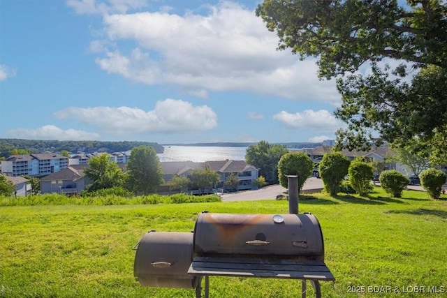 view of home's community with a lawn and a water view