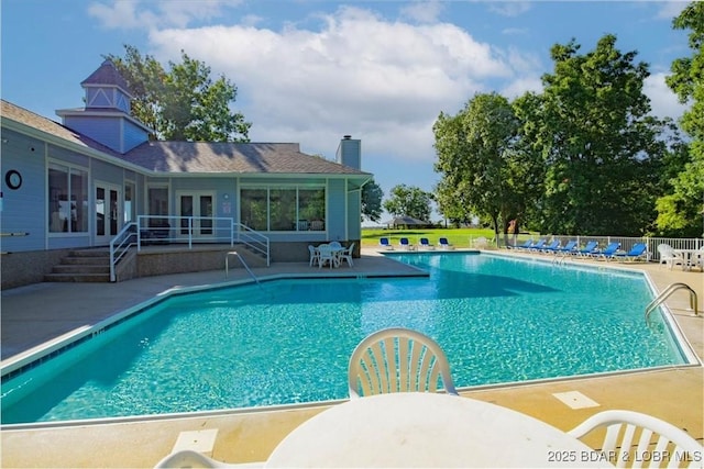 pool with french doors and a patio