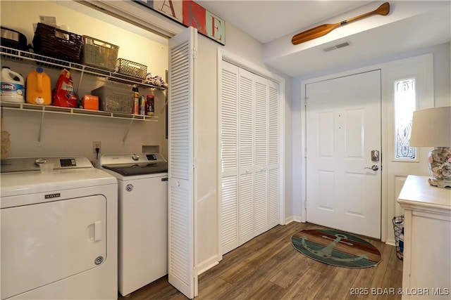 washroom featuring laundry area, visible vents, wood finished floors, and washing machine and clothes dryer