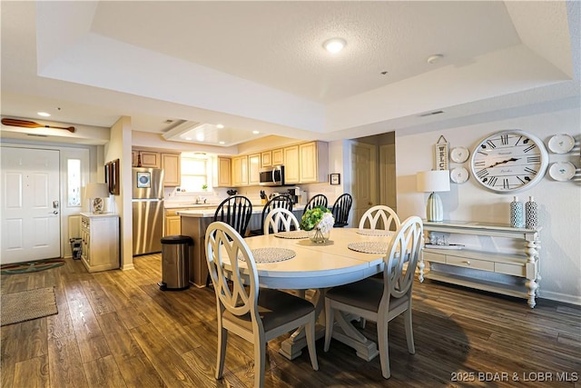 dining space with baseboards, a raised ceiling, dark wood finished floors, and recessed lighting