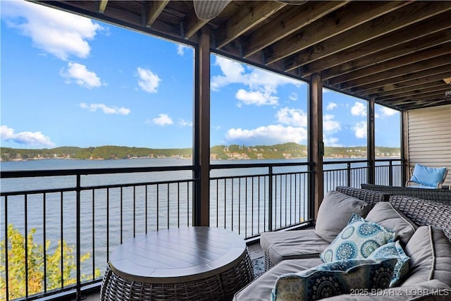 balcony featuring a water view and an outdoor living space