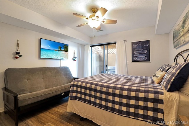 bedroom featuring ceiling fan, a textured ceiling, wood finished floors, and access to exterior