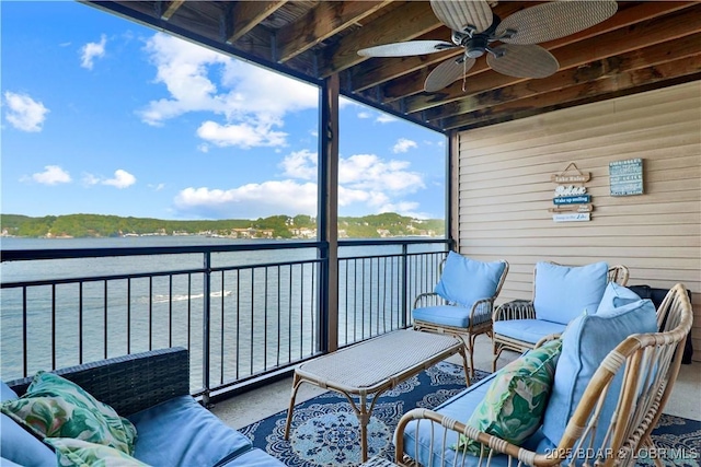 balcony with outdoor lounge area, a water view, and a ceiling fan