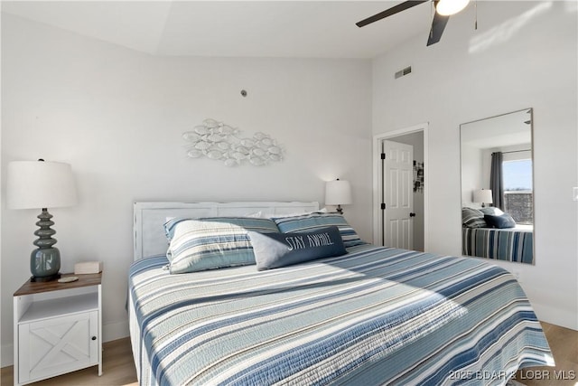 bedroom with ceiling fan, wood finished floors, visible vents, and baseboards