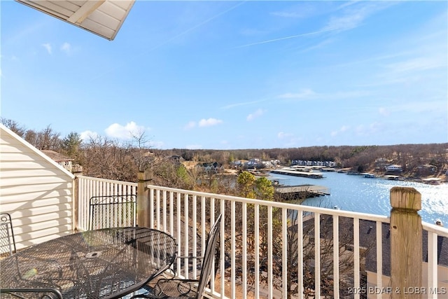 balcony with a water view and outdoor dining space