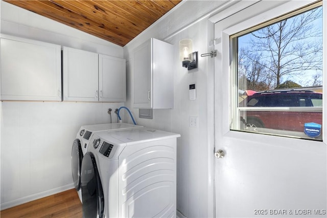 laundry area with cabinet space, wood ceiling, separate washer and dryer, wood finished floors, and baseboards