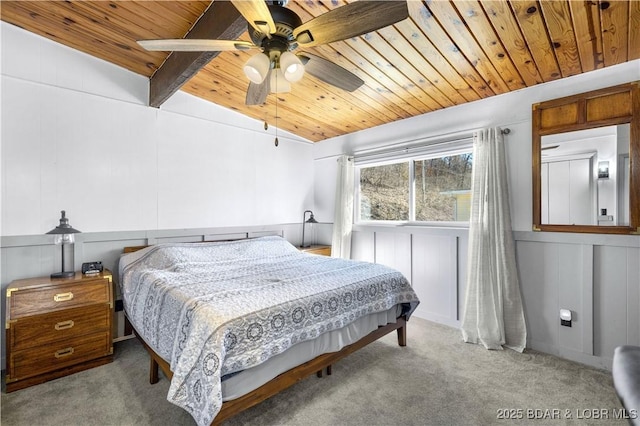 carpeted bedroom featuring vaulted ceiling with beams, wooden ceiling, ceiling fan, and a decorative wall