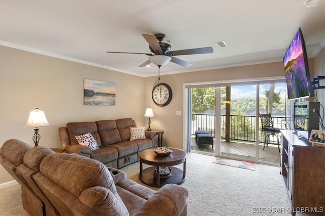 carpeted living room featuring baseboards, a ceiling fan, visible vents, and crown molding