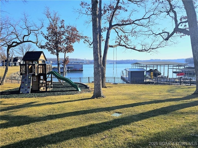 community jungle gym featuring a yard, a water view, and fence