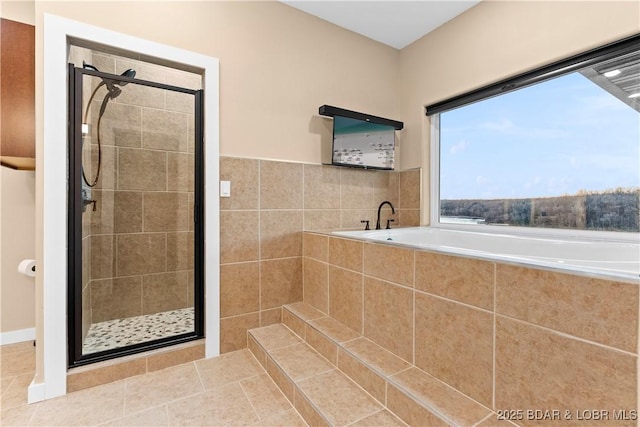 bathroom featuring a stall shower, a bath, and tile patterned floors