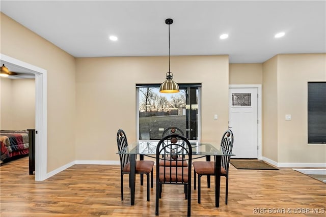 dining room with baseboards, wood finished floors, and recessed lighting