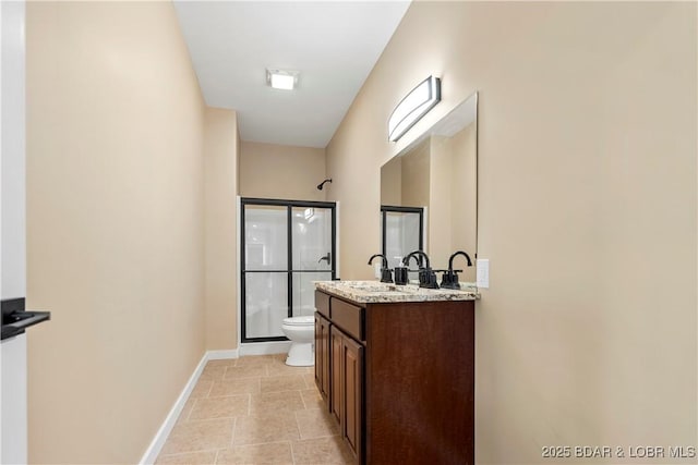 bathroom with toilet, a shower stall, baseboards, and vanity