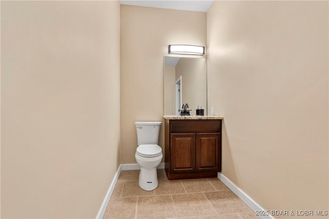 half bath featuring tile patterned flooring, vanity, toilet, and baseboards