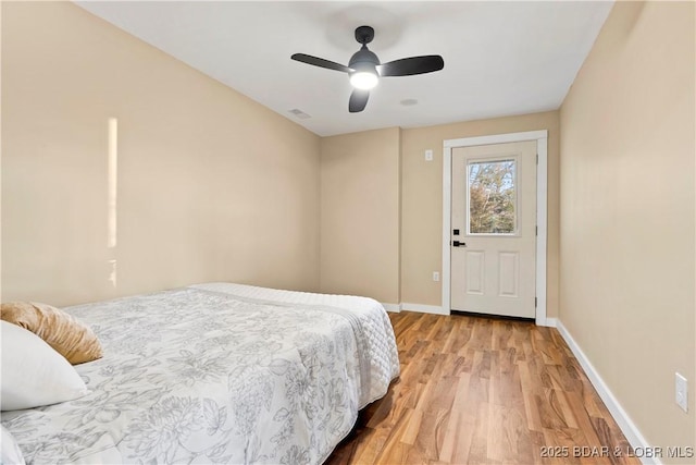 bedroom with a ceiling fan, light wood-type flooring, visible vents, and baseboards