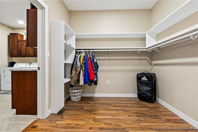 walk in closet with wood finished floors