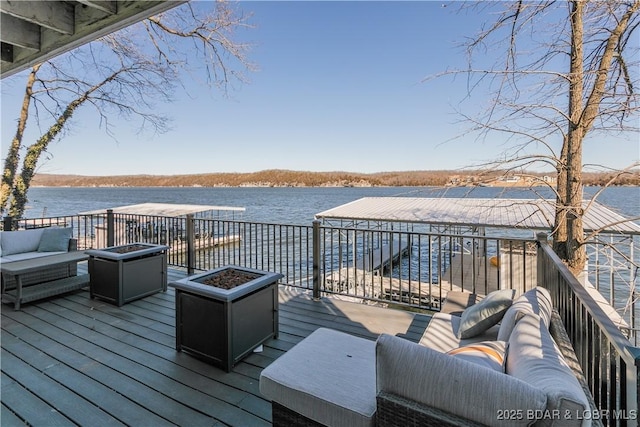 wooden terrace featuring an outdoor living space with a fire pit and a water view