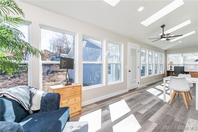 sunroom with vaulted ceiling with skylight and ceiling fan