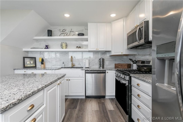 kitchen featuring white cabinetry, decorative backsplash, stainless steel appliances, and a sink