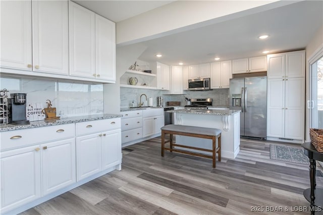 kitchen with light wood-style floors, white cabinetry, appliances with stainless steel finishes, and open shelves