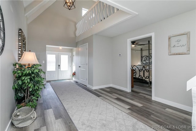 entryway featuring french doors, wood finished floors, a high ceiling, and baseboards