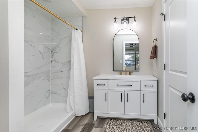 bathroom with a shower stall, wood finished floors, and vanity