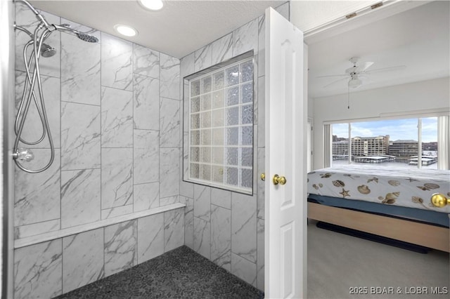 bathroom featuring tiled shower and a ceiling fan