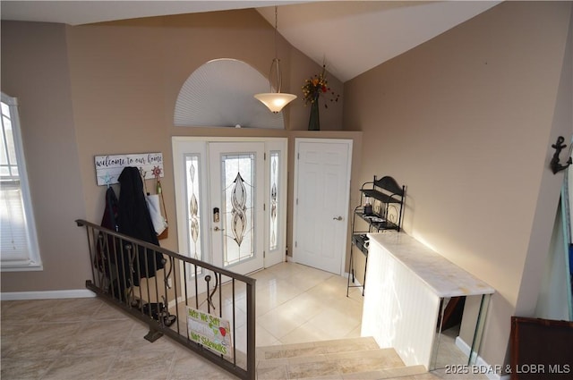 entryway featuring high vaulted ceiling, baseboards, and light tile patterned floors