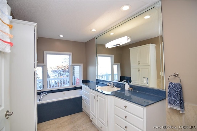 full bathroom with tile patterned flooring, vanity, a bath, and recessed lighting