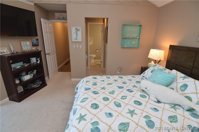 bedroom featuring carpet, ensuite bath, and baseboards