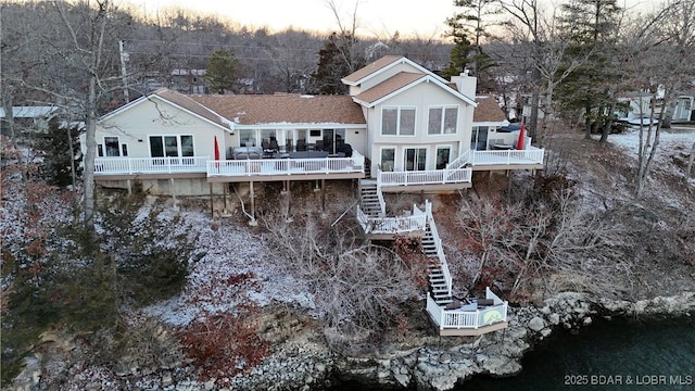 back of property featuring stairs, a chimney, and a deck