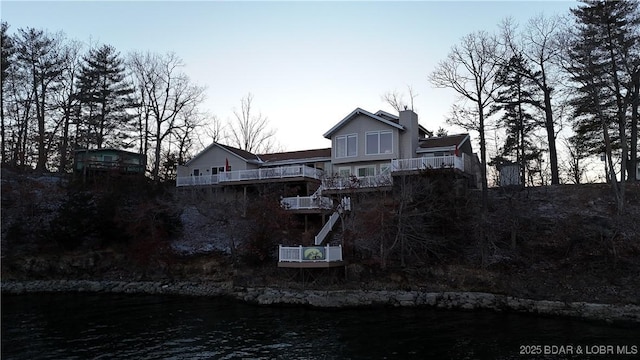 exterior space featuring a balcony and a chimney