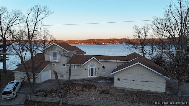 view of front of property featuring a water view and fence