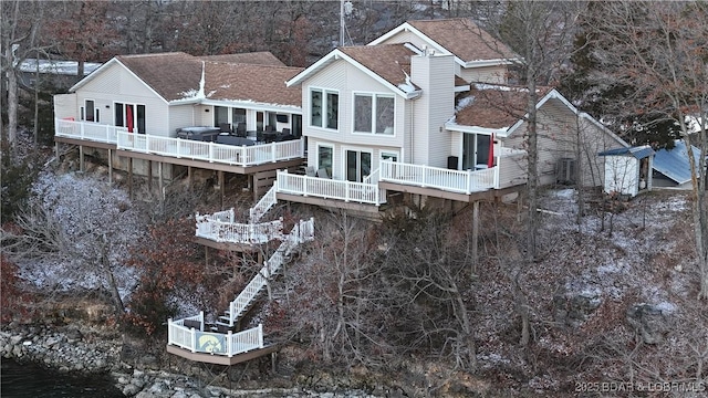 rear view of property featuring roof with shingles