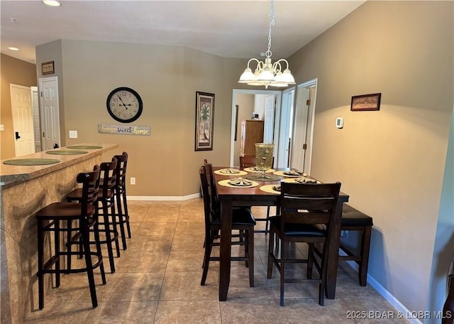 dining area featuring a chandelier, tile patterned flooring, and baseboards