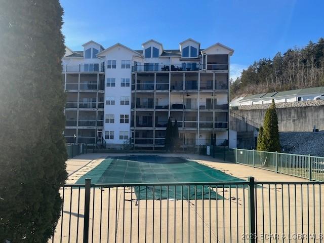 community pool with fence and a patio